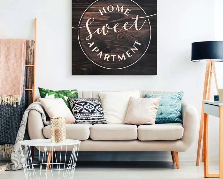living room with "home sweet apartment" wall art - apartment decor tips - Gear Den