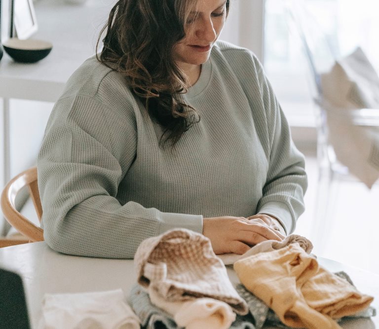 mom folding clothes - home organizing tips to prevent clutter