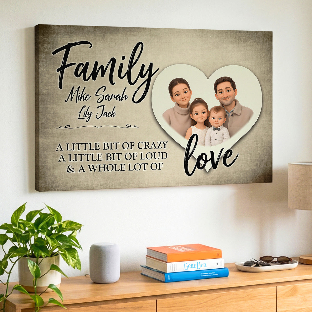 A personalized canvas wall art print displayed on a white wall. The print features a textured beige background with black script text reading 'Family' and 'love', custom names 'Mike', 'Sarah', and 'Lily Jack', and a heart-shaped photo frame containing an animated cartoon family portrait.