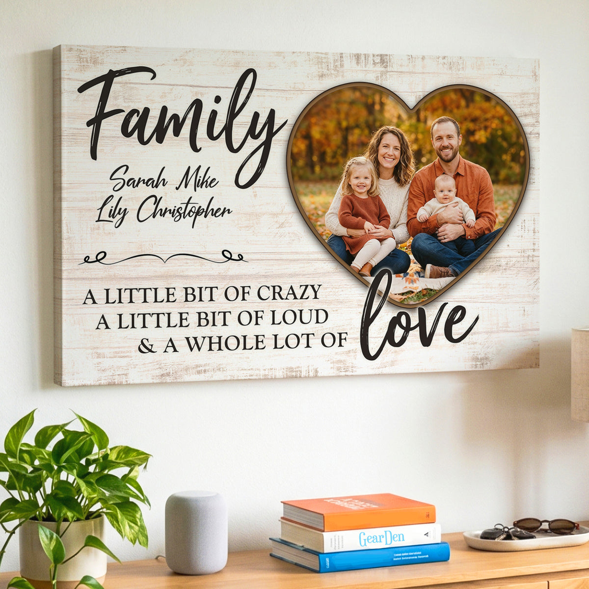 Personalized family photo canvas hanging above a sideboard, with a family of four in an autumn park inside a heart, the names Sarah Mike Lily Christopher, and the words Family, a little bit of crazy, a little bit of loud and a whole lot of love on a whitewashed wood background