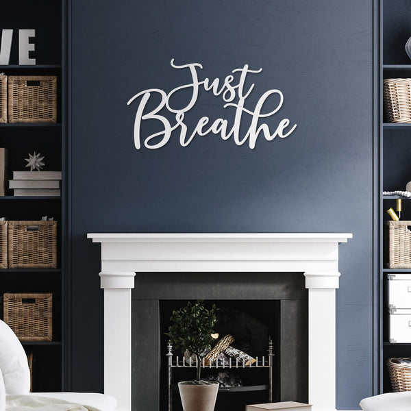 white fireplace on blue wall with metal wall hanging - metal cutout art that says "just breathe" - GearDen